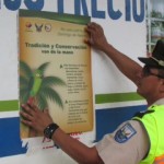 Cabo Stalin Amagua pegando un afiche de prevención