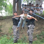 Miembros del GOE Manabí ayudan a niño cursante a realizar la tirolina