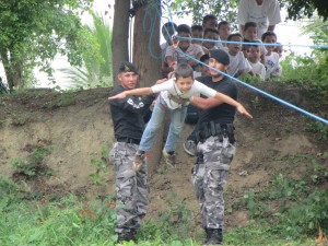 Miembros del GOE Manabí ayudan a niño cursante a realizar la tirolina