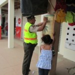 Uniformado junto a niños pegando afiche de prevenciónJPG